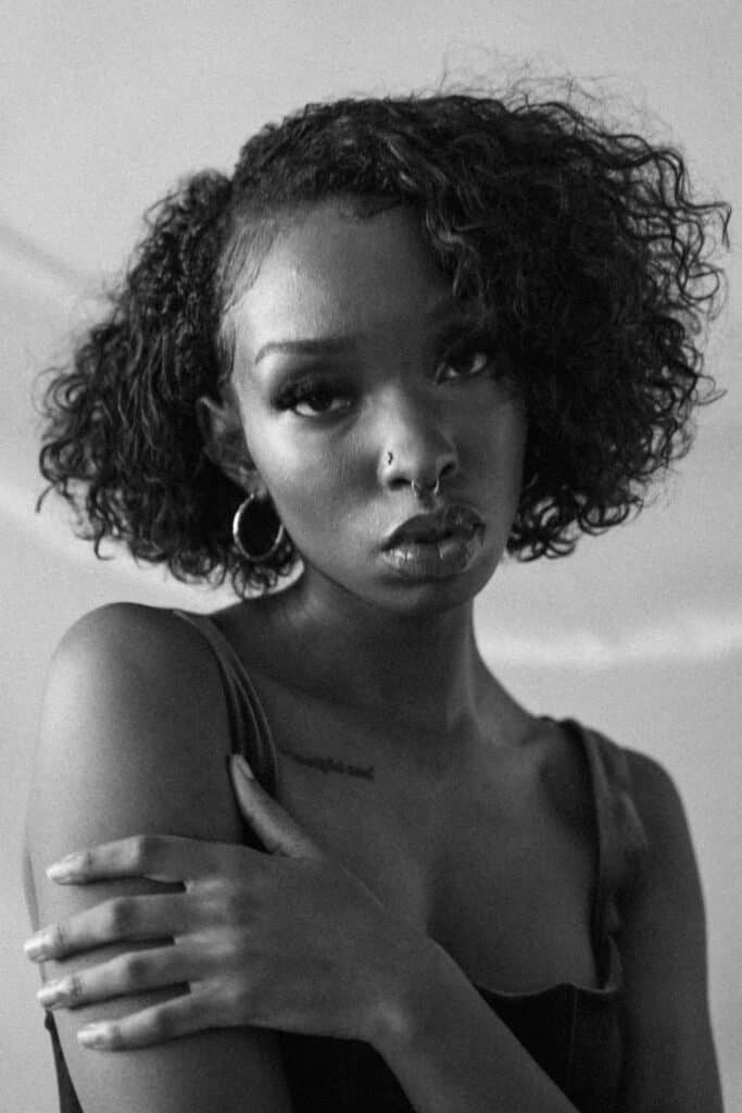 Seattle model Dymond poses in a Zara dress behind tulle in a moody black and white photo by Zur Photography.